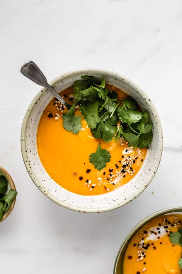 A bowl of butternut squash soup topped with cilantro