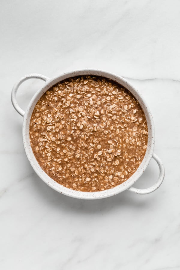 a round baking dish with baked oatmeal batter in it