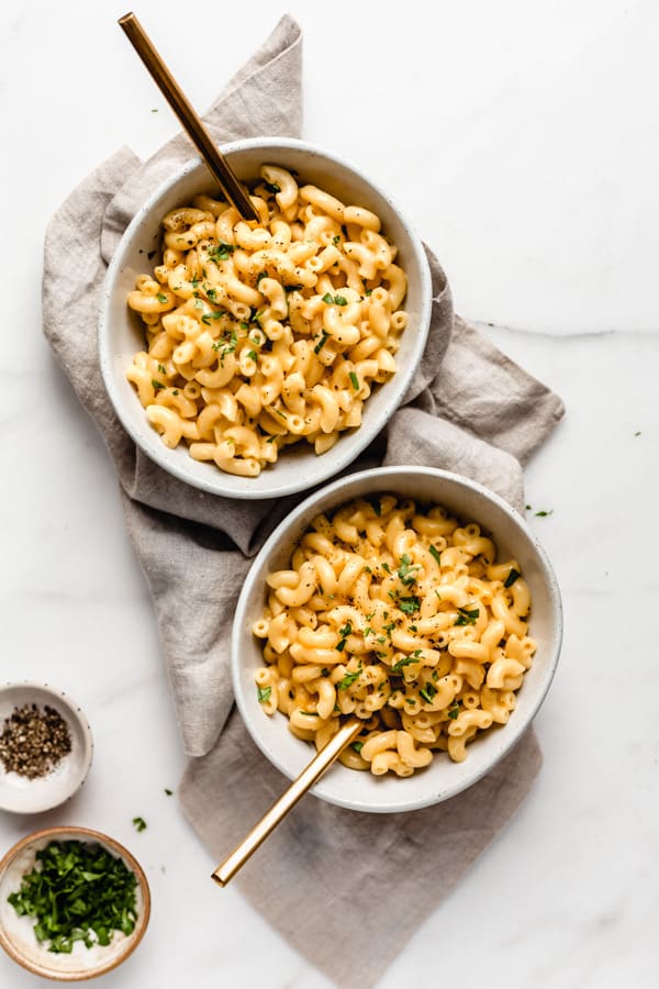 two bowls of mac and cheese on a taupe coloured napkin
