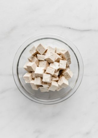 cubes of tofu in a clear mixing bowl