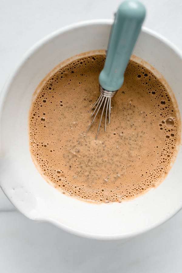chai latte chia pudding mixture in a bowl with a whisk