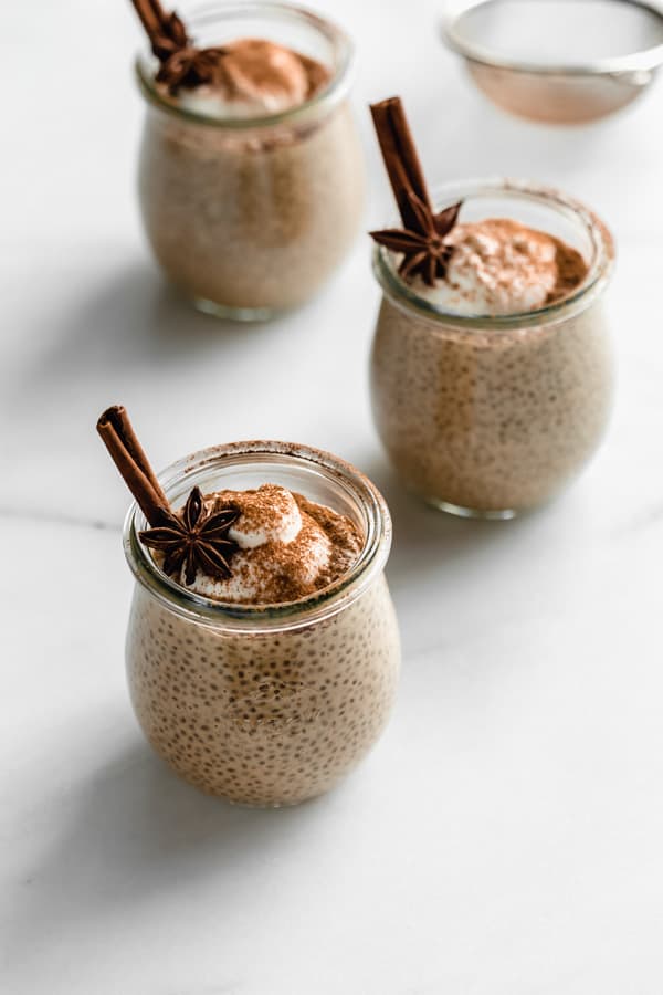 three chai latte chia pudding cups on a white marble board