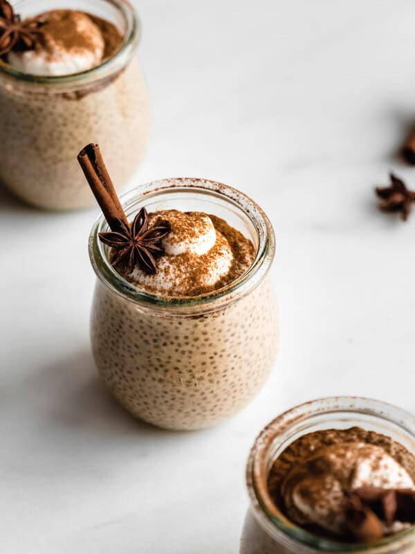 a cup of chai latte chia pudding topped with yogurt, cinnamon and star anis