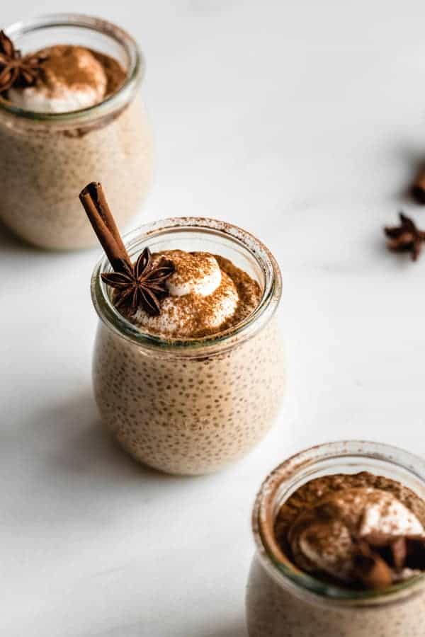 a cup of chai latte chia pudding topped with yogurt, cinnamon and star anis