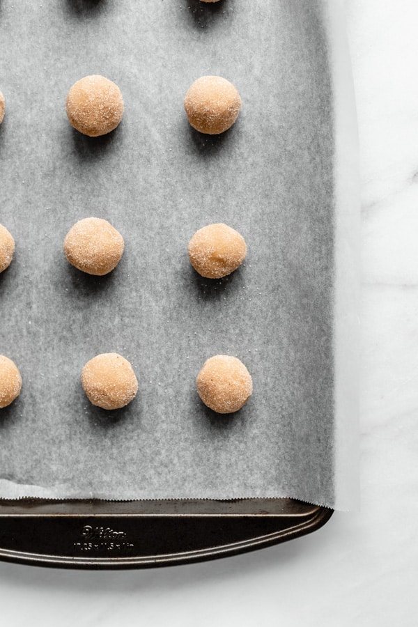 snickerdoodle cookie dough balls on a baking sheet