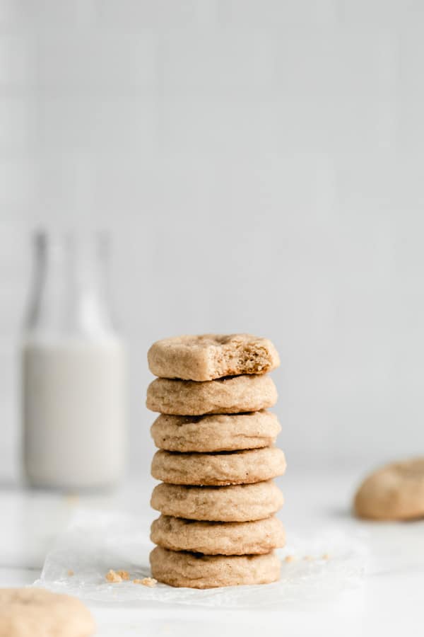 a stack of seven snickerdoodle cookies with a jar of milk in the back