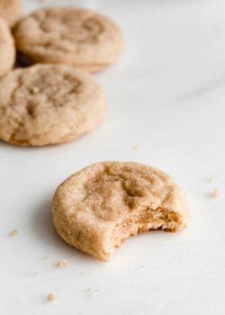 a snickerdoodle cookie on a marble board with a bite taken out of it