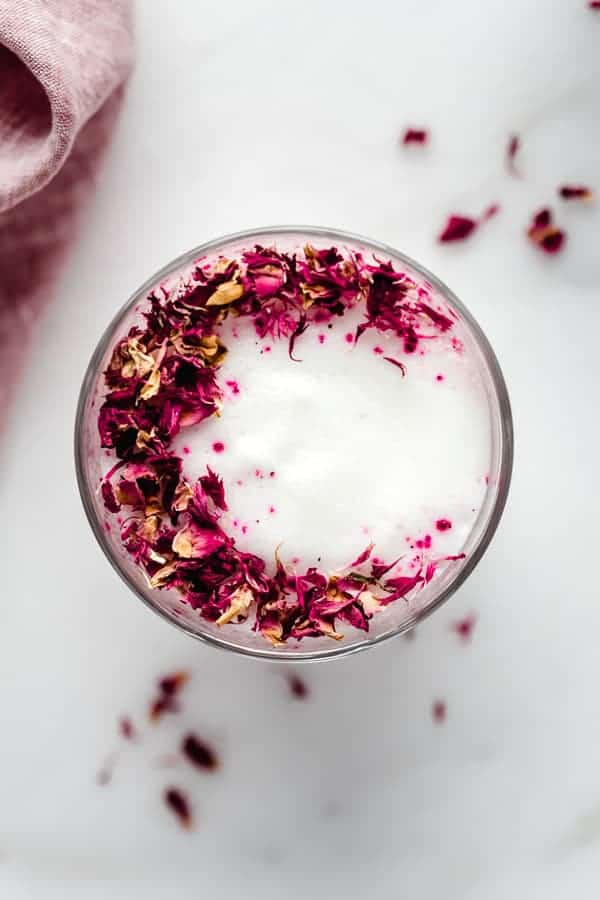 a hibiscus rose latte topped with rose petals