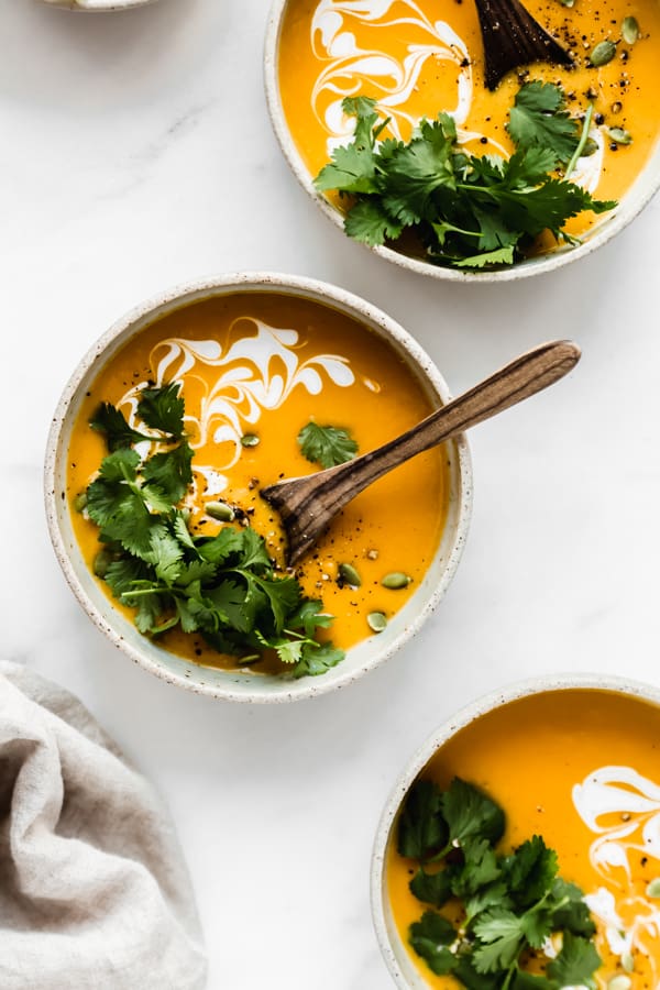 A bowl of butternut squash soup topped with cilantro