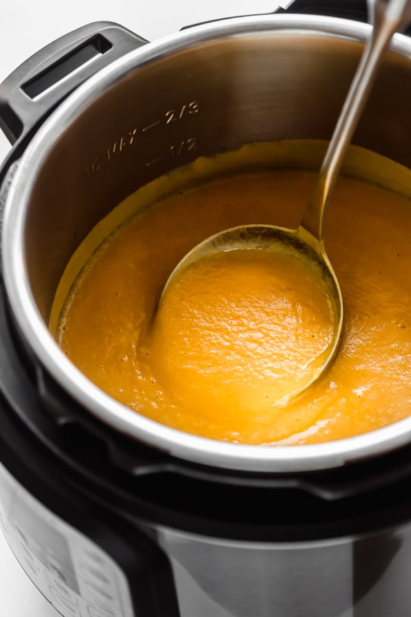 a ladle scooping a spoonful of butternut squash soup in an instant pot