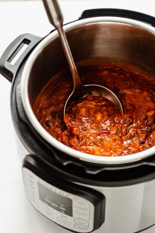 a ladle scooping chili out of an instant pot