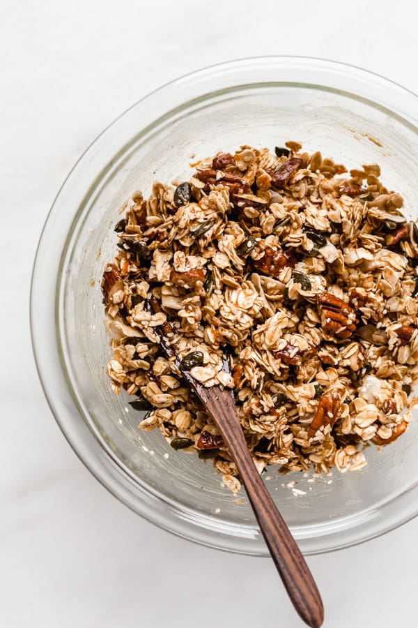 a clear mixing bowl with un-baked tahini granola in it