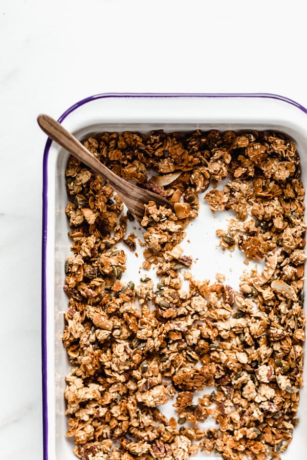 a baking white enamel baking pan with baked tahini granola in it