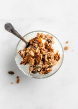 a top down view of a cup of yogurt topped with orange cardamom tahini granola