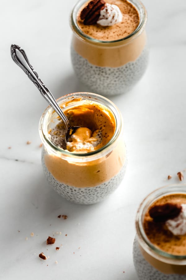a jar of pumpkin pie chia pudding with a spoon in it