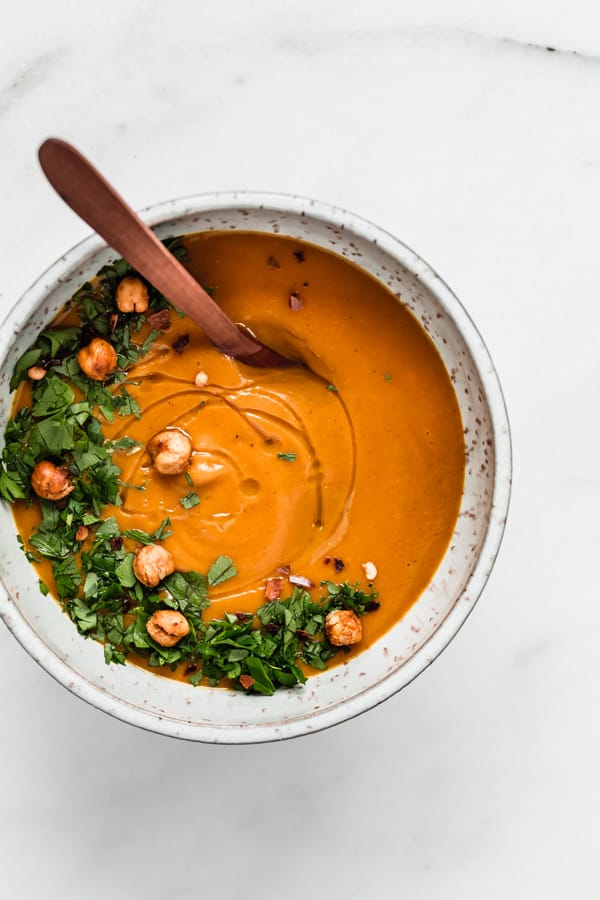a bowl of sweet potato soup topped with parsley