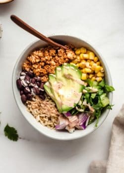 A bowl of chipotle sofrtias with avocado, rice, beans, corn and lettuce