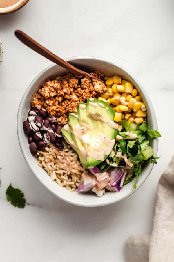 A bowl of chipotle sofrtias with avocado, rice, beans, corn and lettuce