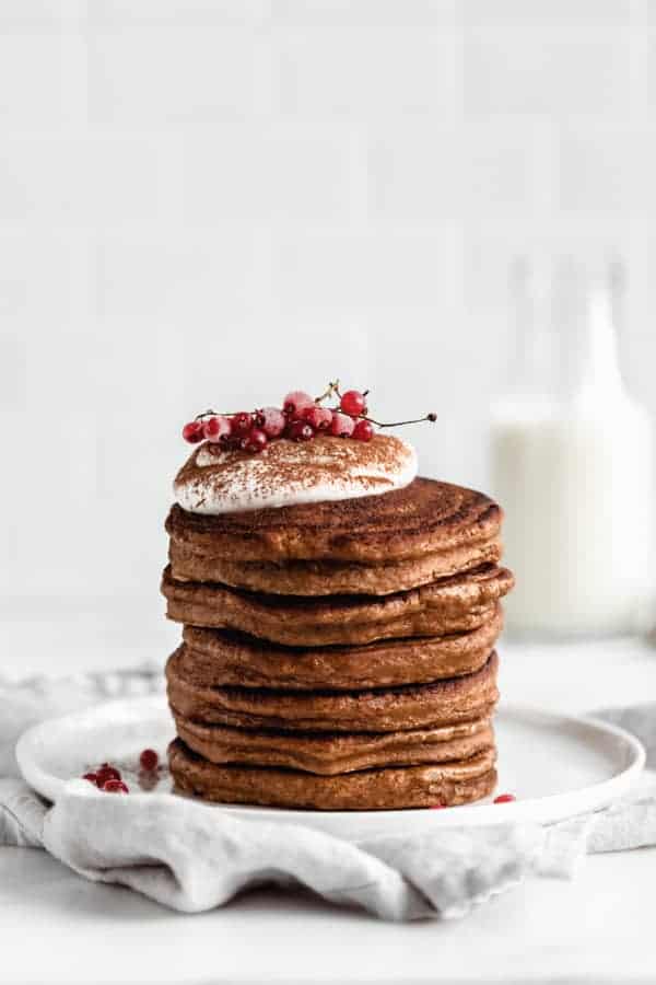 a stack of gingerbread pancakes topped with yogurt and currants