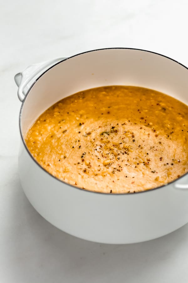 A white pot filled with red lentil dal