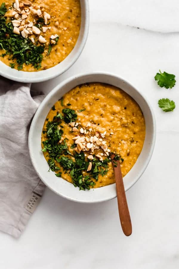 a bowl of Sri Lankan red lentil dal topped with cilantro and peanuts