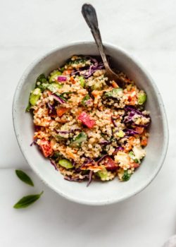 A bowl of Thai Quinoa Salad with some basil leave on the side