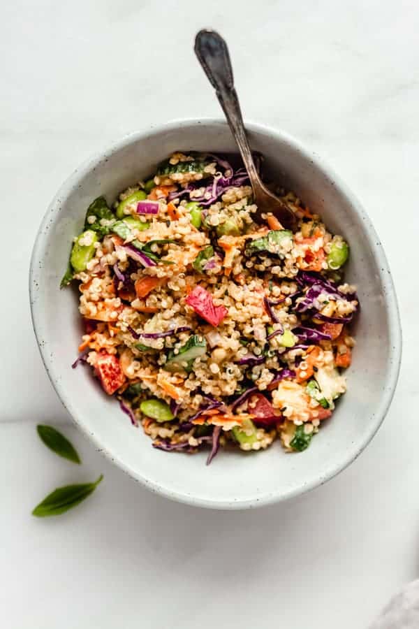 A bowl of Thai Quinoa Salad with some basil leave on the side