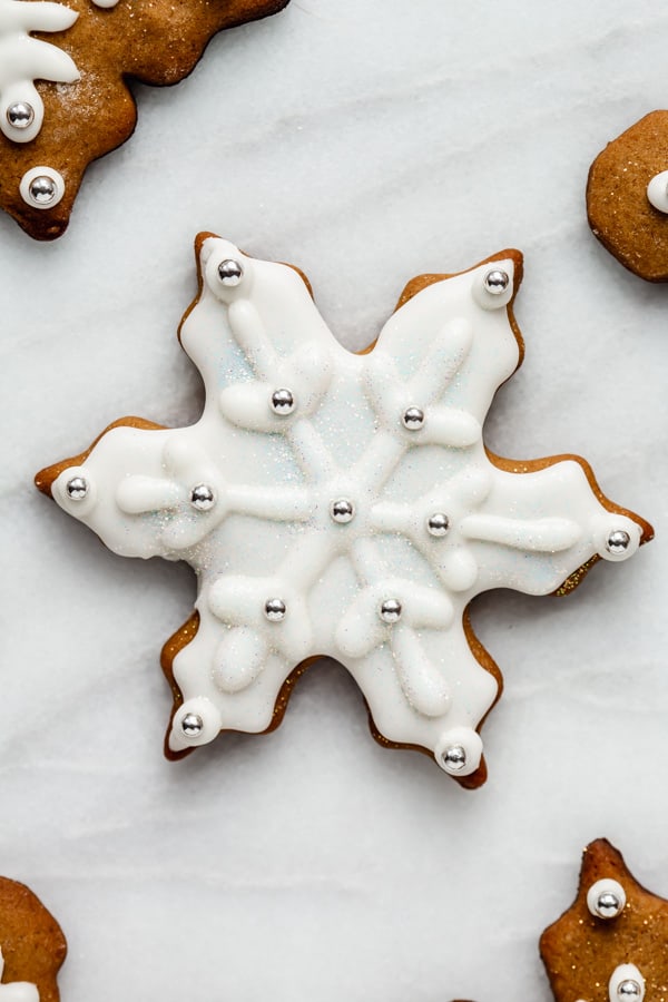 a snowflake gingerbread cookie covered in royal icing