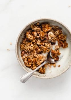 a bowl with banana bread granola and a spoon in it