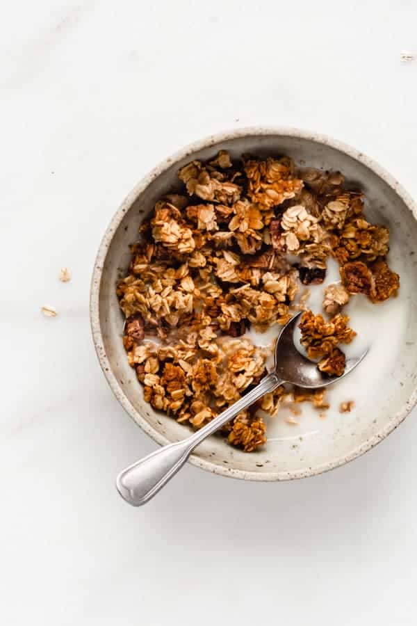 a bowl with banana bread granola and a spoon in it