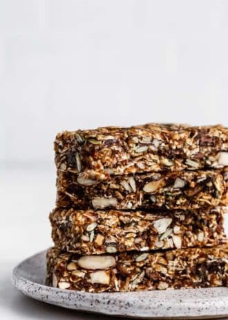 a stack of four superfood granola bars on a white ceramic plate