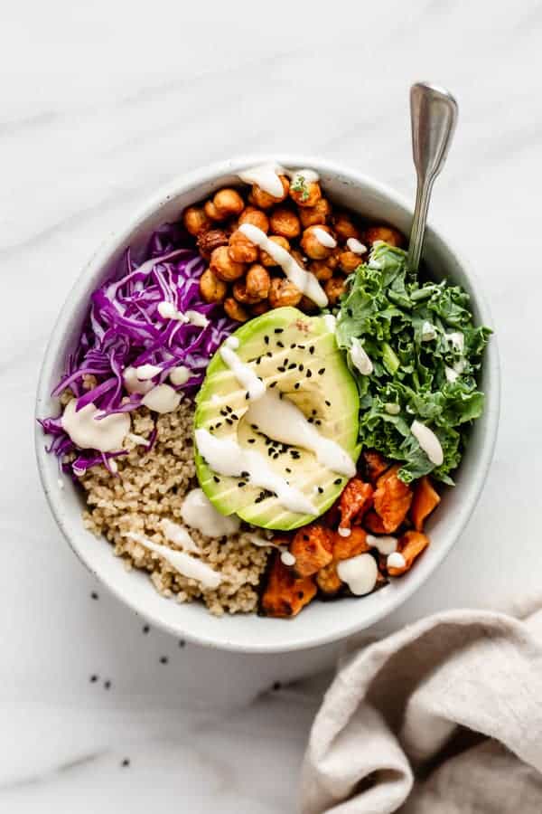 A bowl with quinoa avocado and vegetables in it