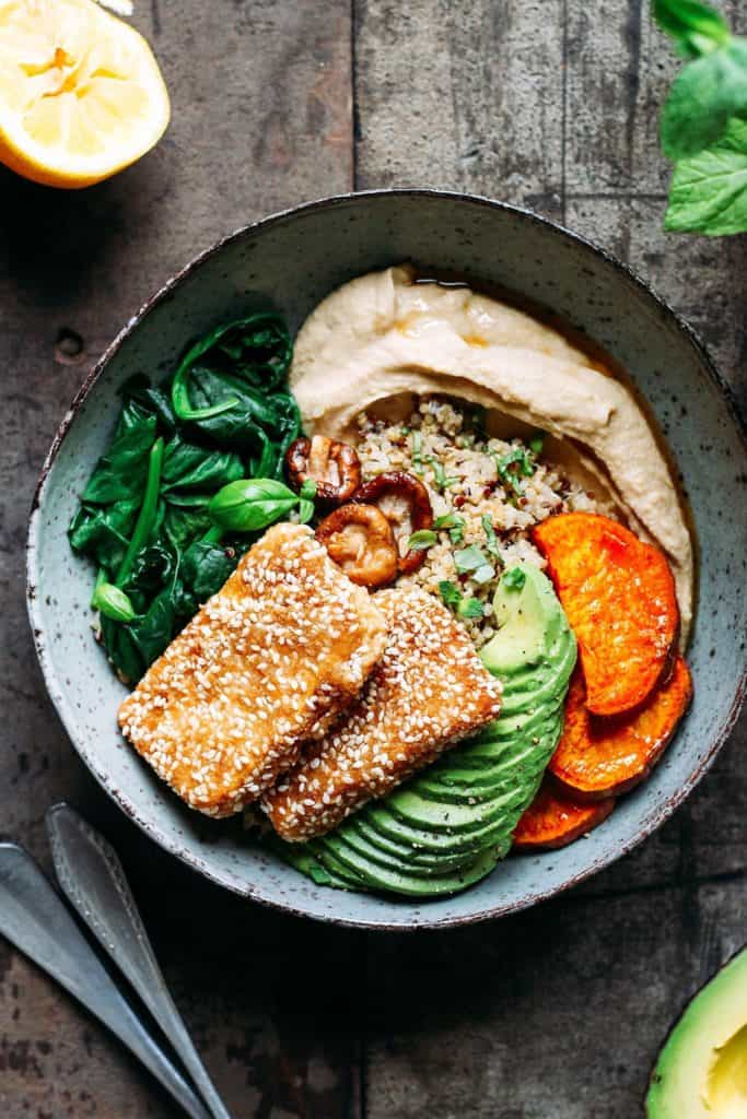 A bowl with quinoa, sweet potato and crusted tofu in it