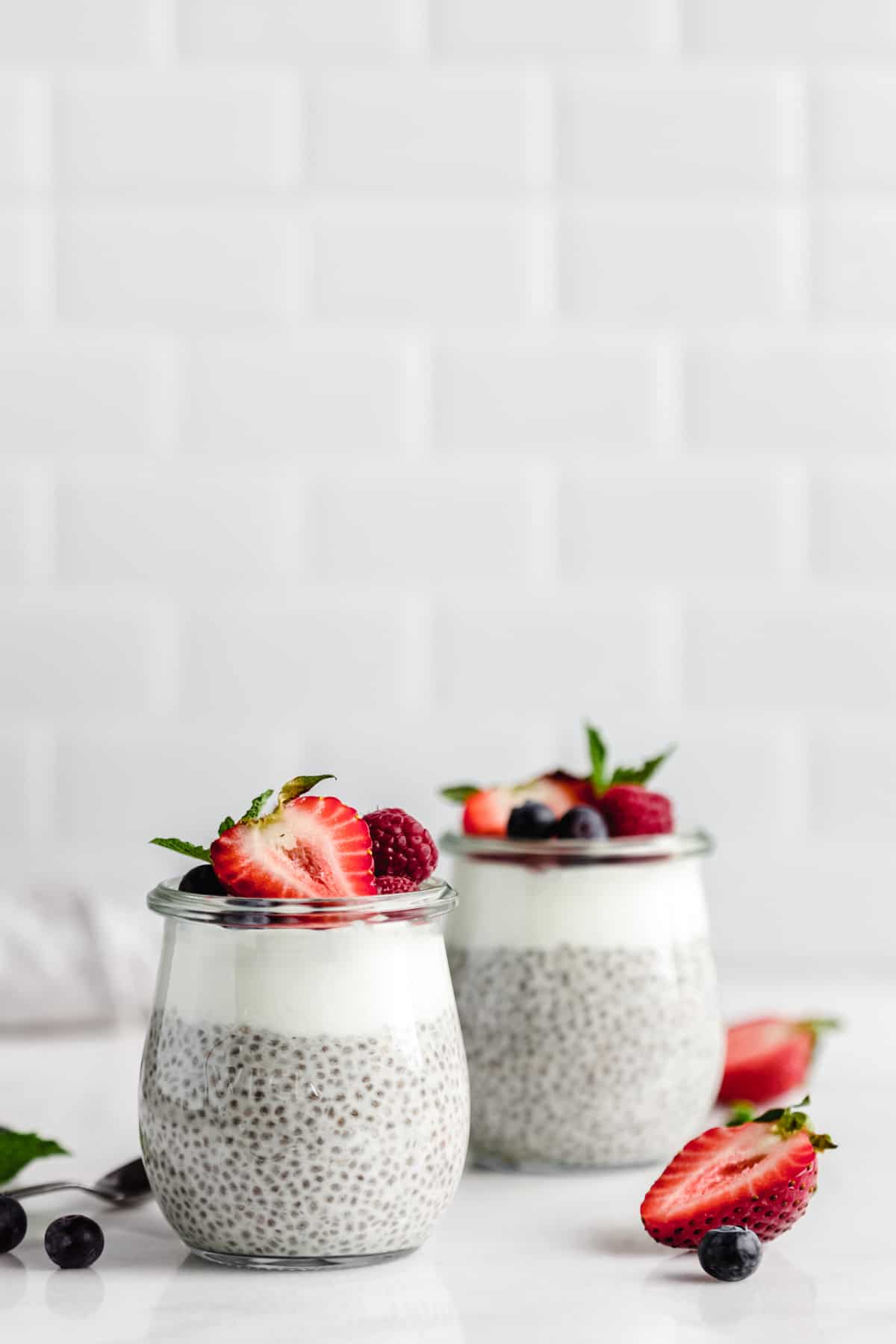 two cups of vanilla chia pudding topped with berries