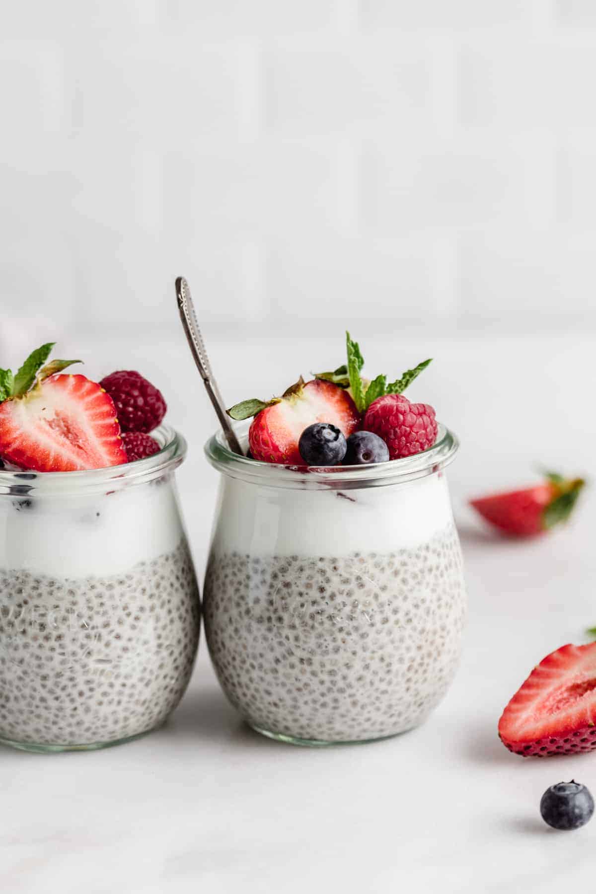 a cup of chia pudding with berries and a spoon in it