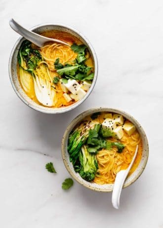 two bowls of vegetarian laksa on a marble board