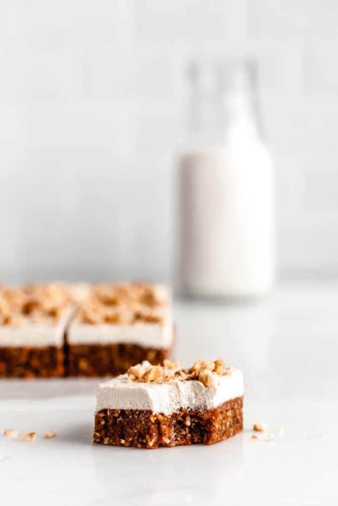 a square of raw carrot cake with a bite taken out of it