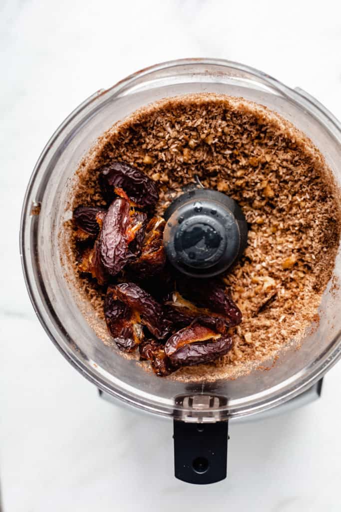 a food processor with blended nuts and dates in it