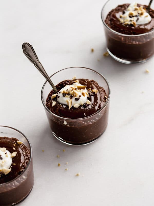 a cup of snickers chia pudding topped with cacao nibs, crushed peanuts and yogurt