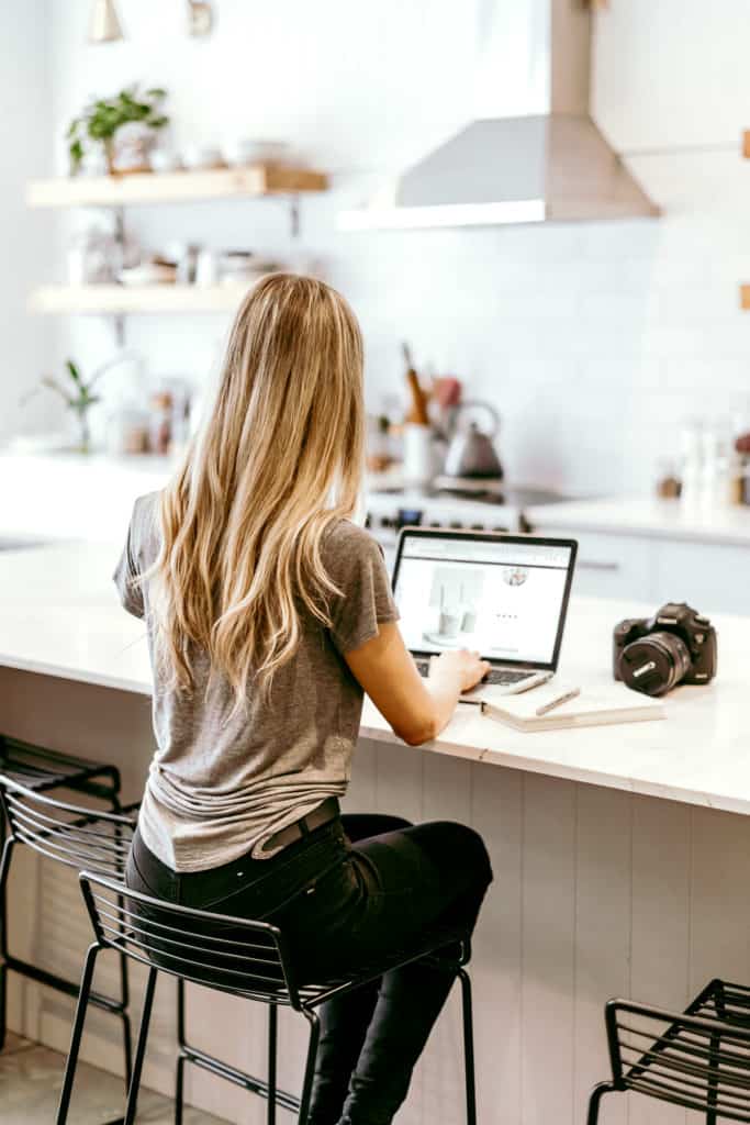 girl sitting at kitchen island on a laptop