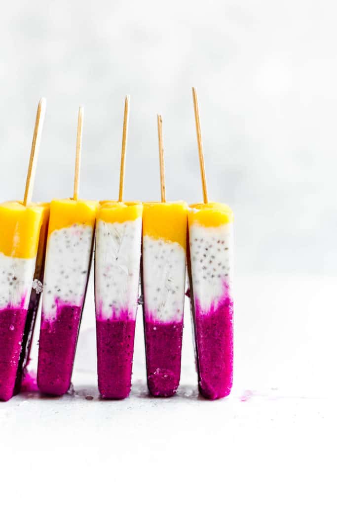 5 tropical coconut chia popsicles stacked next to each other