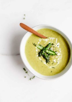 asparagus soup in a white bowl with chopped asparagus on top