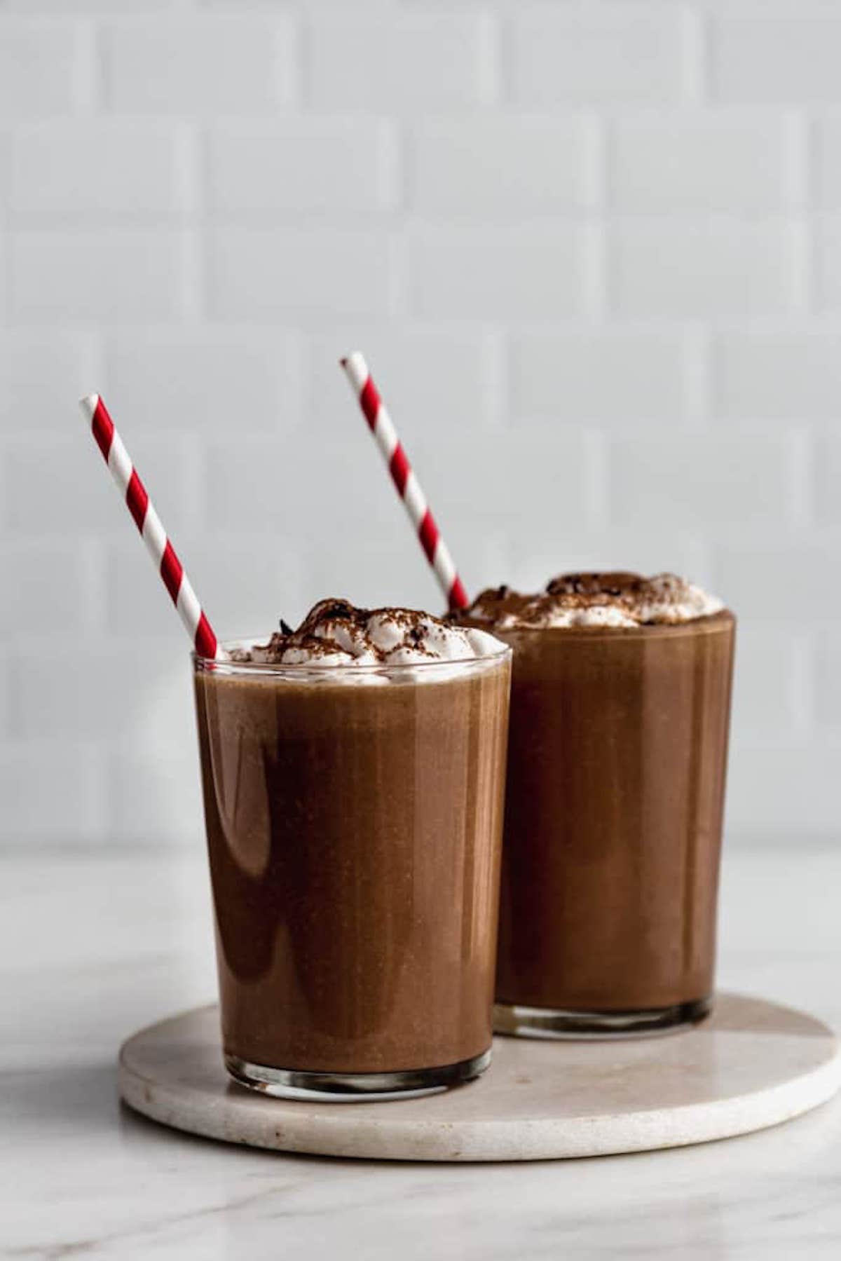 frozen hot chocolate smoothies topped with whipped topping and cocoa powder