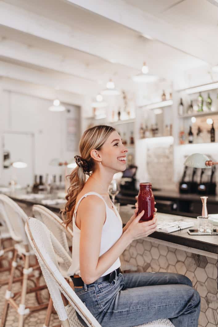 girl sitting at a bar drinking a smoothie