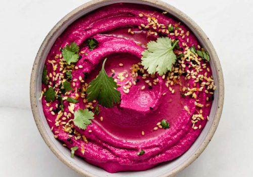 Roasted beet hummus in a bowl on a marble counter