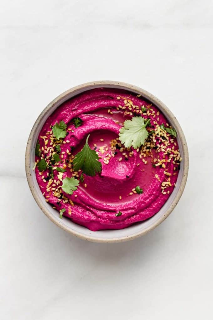 Roasted beet hummus in a bowl on a marble counter