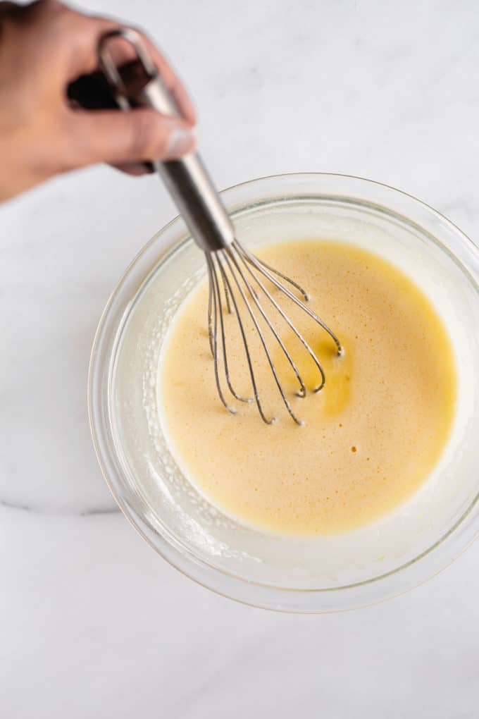 a whisk in a bowl of lemon curd