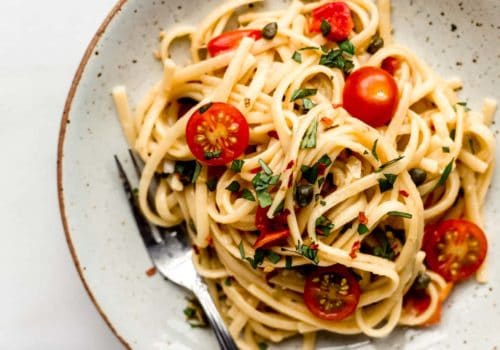 linguine pasta with cherry tomatoes on a white ceramic plate