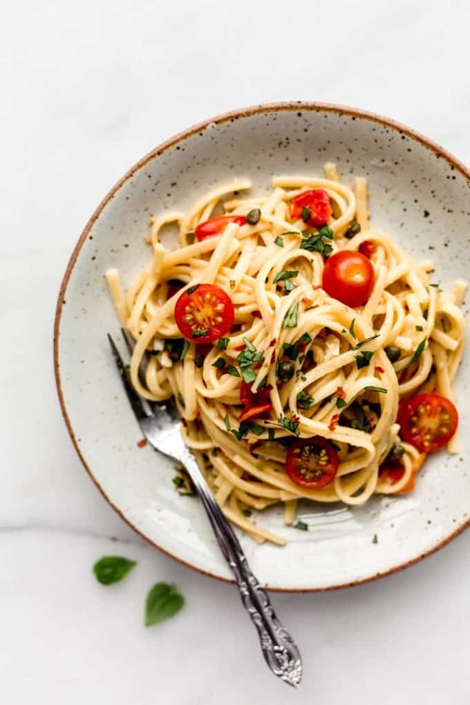 linguine pasta with cherry tomatoes on a white ceramic plate