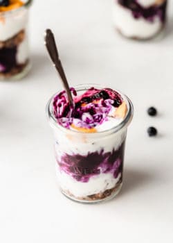 a jar of yogurt with blueberry compote and mango